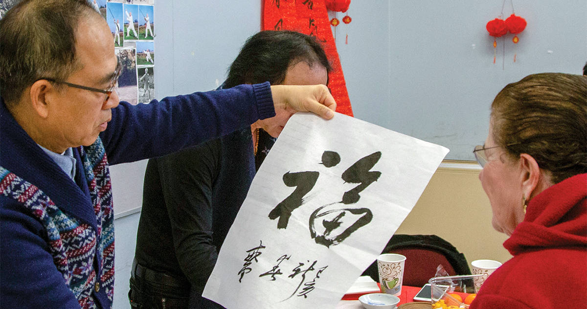 teacher demonstrating brush calligraphy at the Avenidas Chinese Community Center
