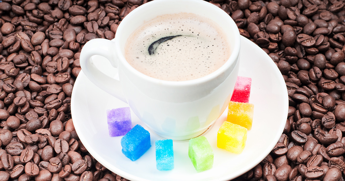 Coffee cup encircled by colored sugar cubes.